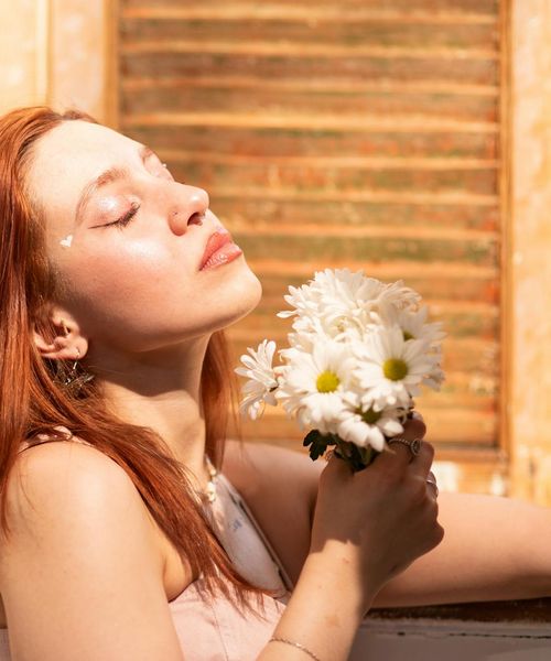Person feeling relaxed with closed eyes in a bright room